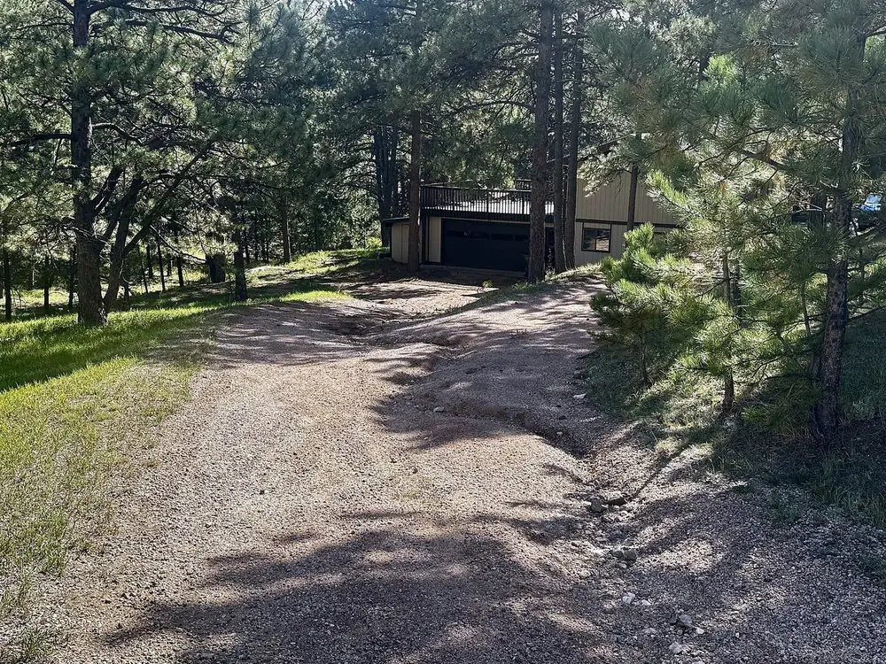 Before: rutted gravel driveway in Evergreen, Colorado with a washout channel down one side, seen from the top